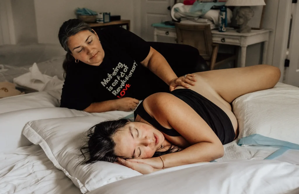 A person giving a massage to another lying on a bed.