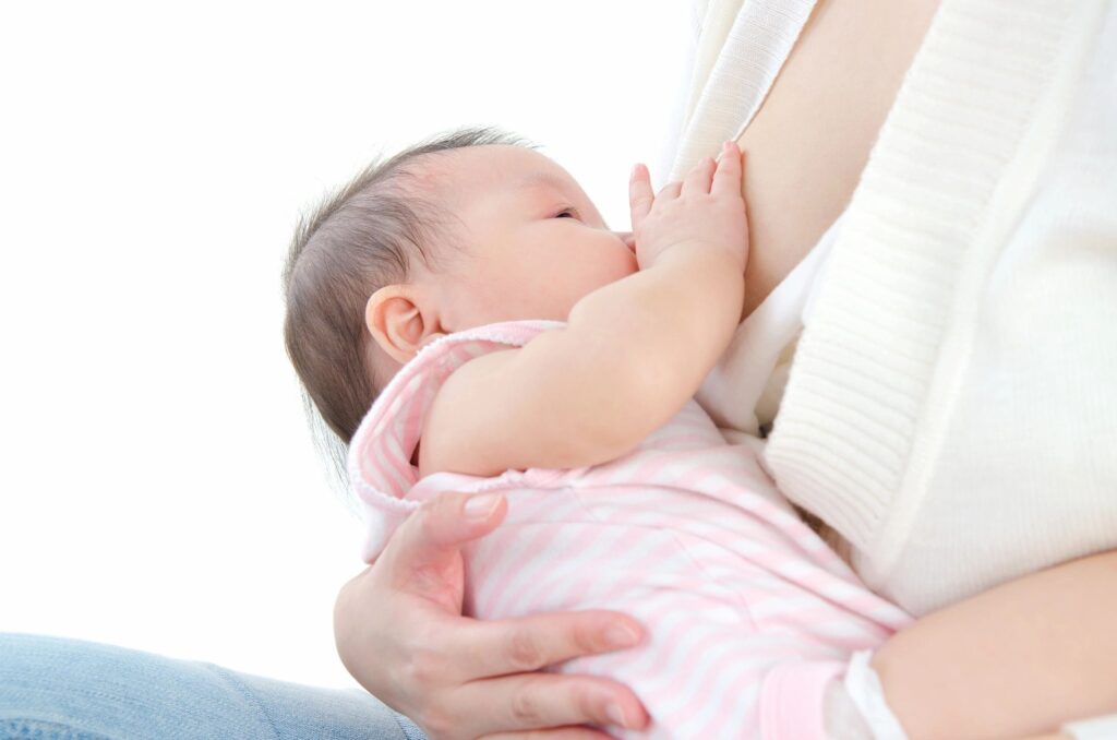 A baby breastfeeding while being held gently.