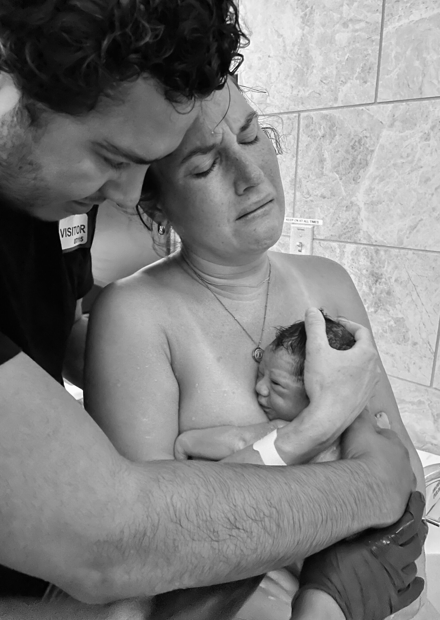 Parents tenderly hold their newborn twins moments after birth.