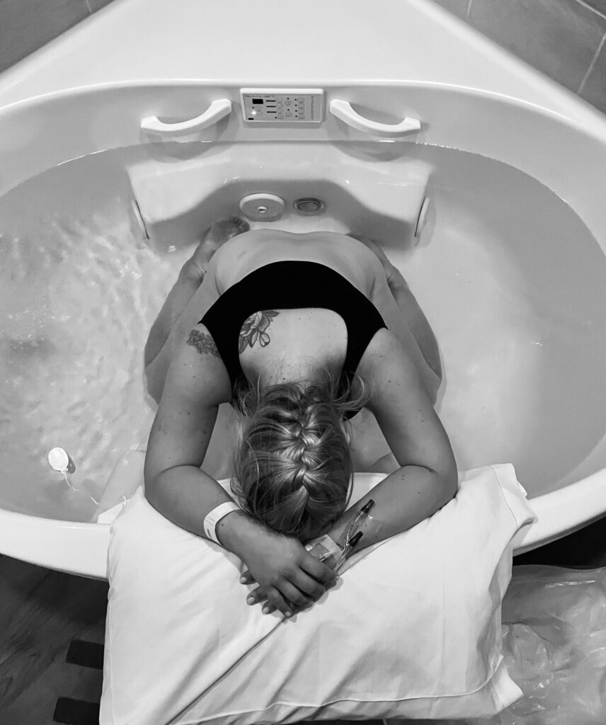 A woman relaxing in a bathtub with her head resting on the edge.