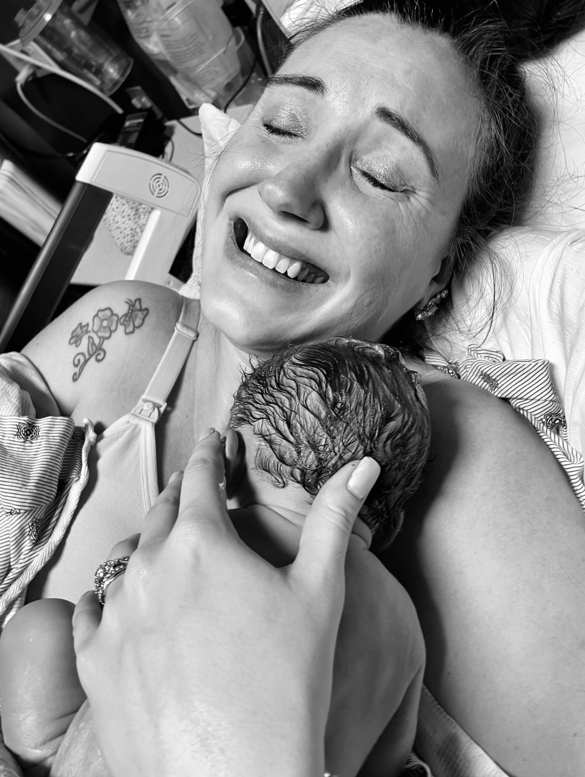A joyful mother holds her newborn baby close after birth.