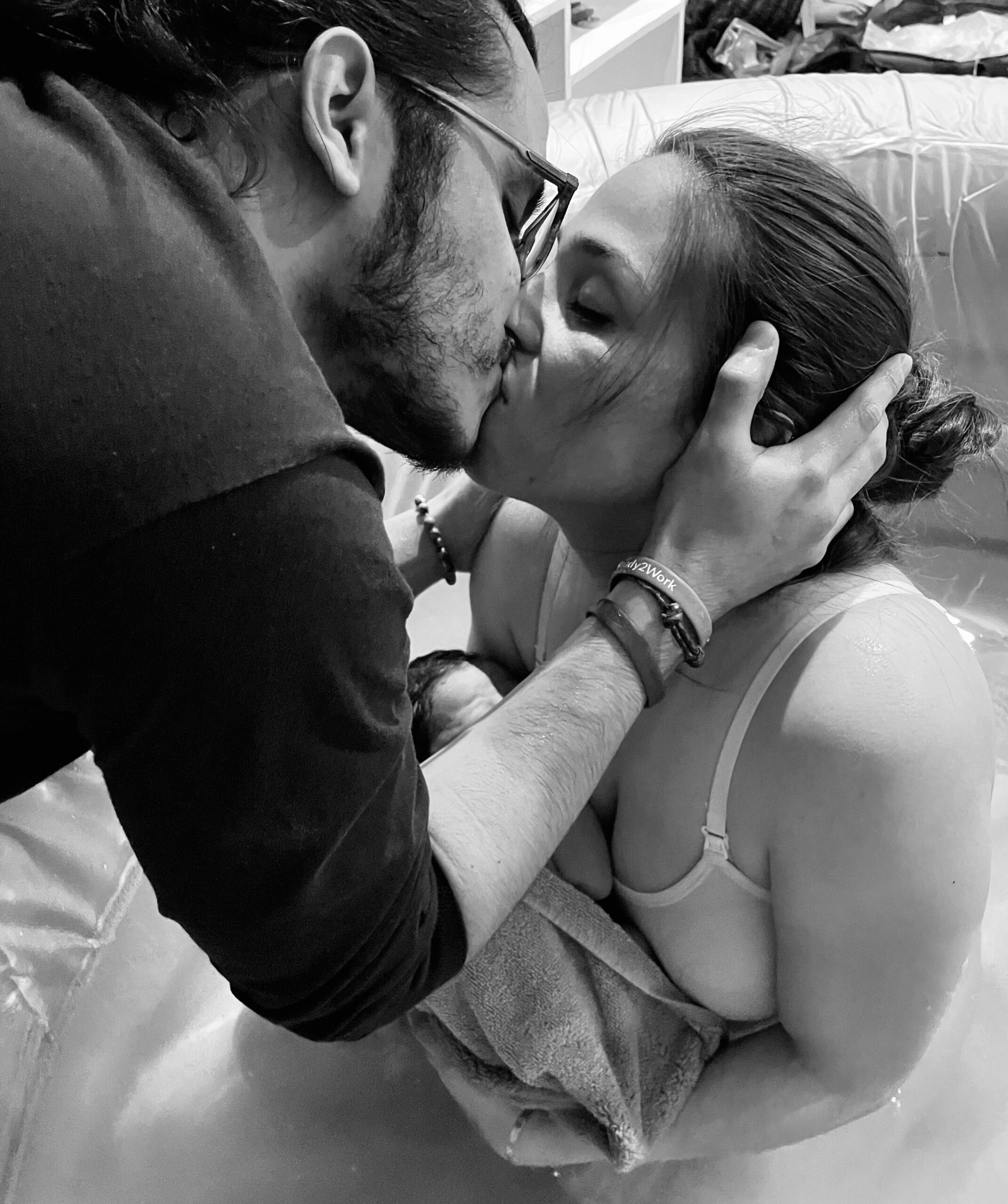 A tender moment of a couple sharing a kiss in black and white.
