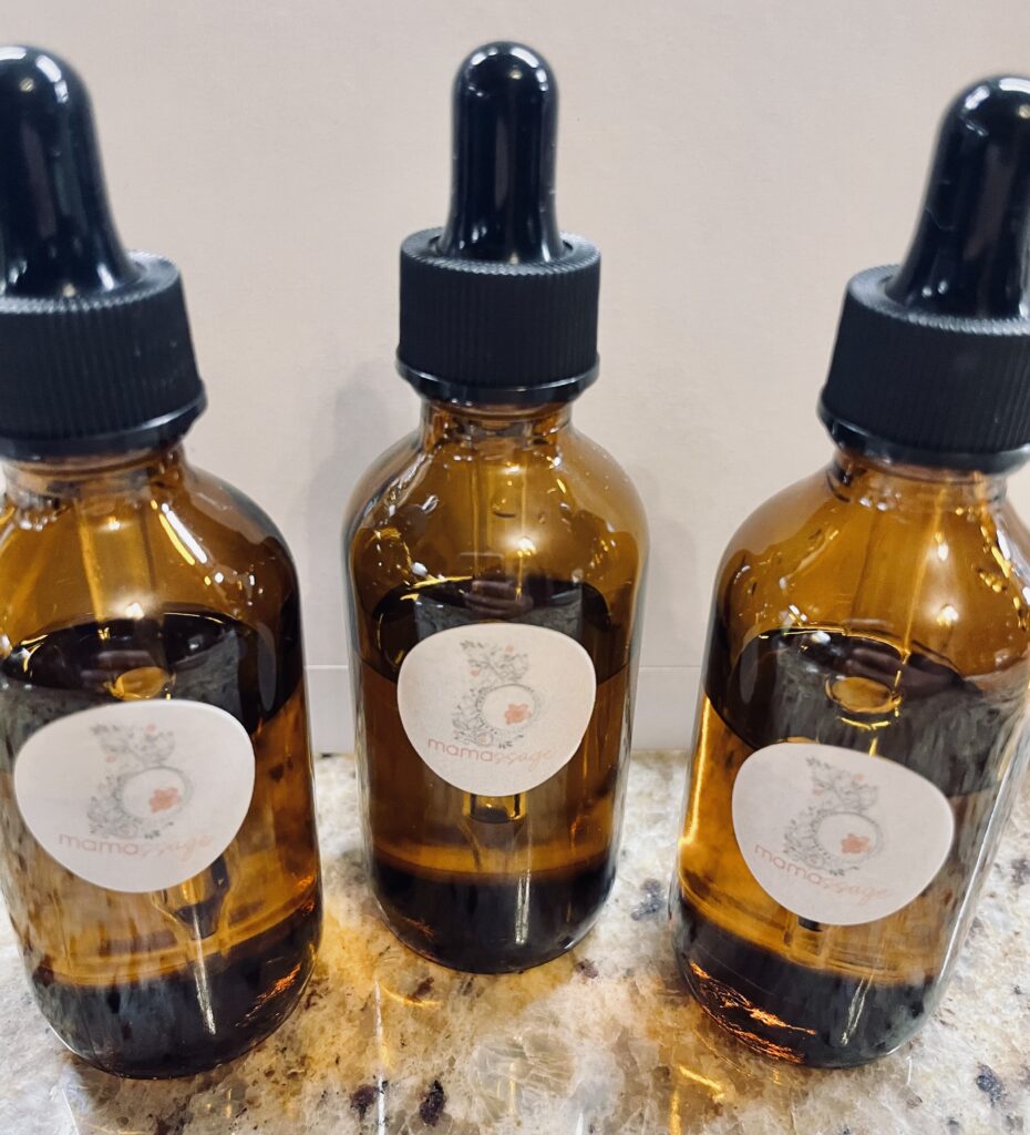 Three amber glass dropper bottles with white labels on a marble surface.